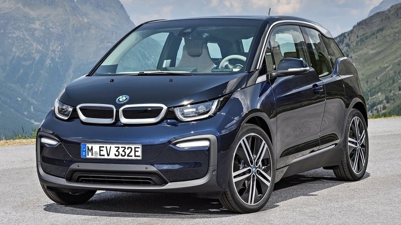 a blue bmw i3 is parked on the side of the road