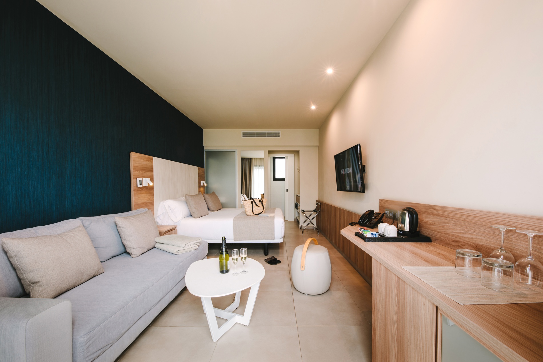 Modern hotel room at Club Maspalomas Suites & Spa with king bed and sofa.