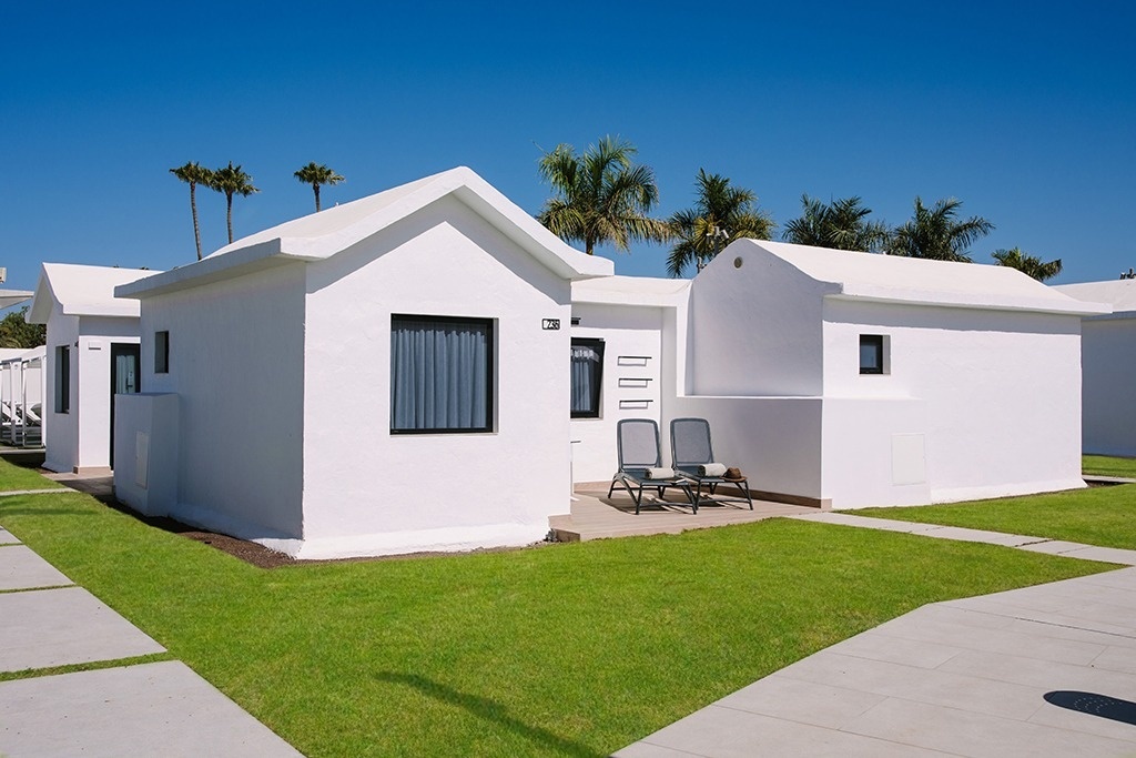 una pequeña casa blanca con la puerta abierta