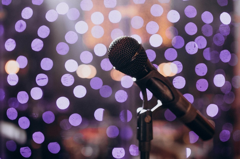 a microphone on a stand with purple lights in the background