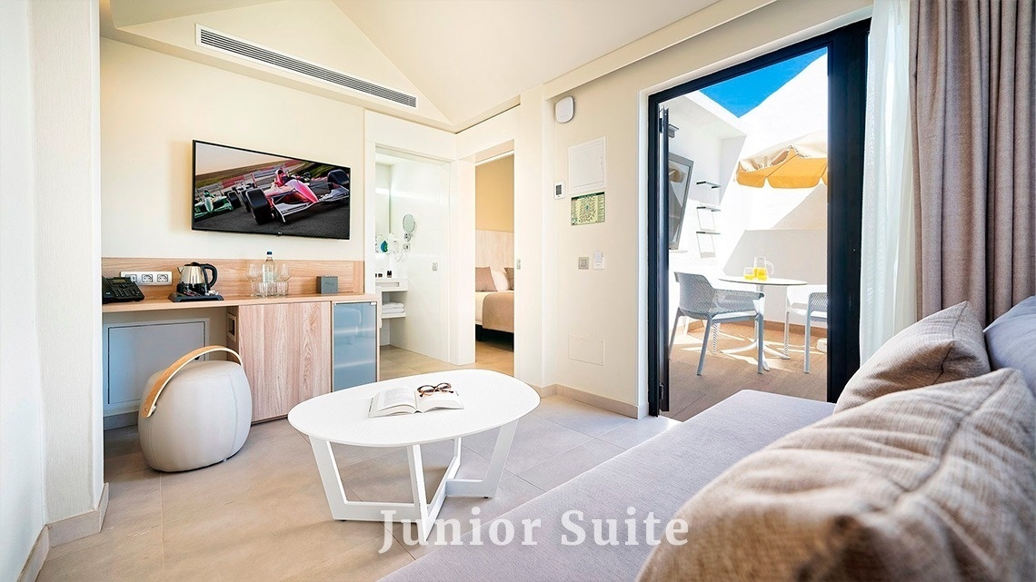 una suite junior con un sofá y una mesa