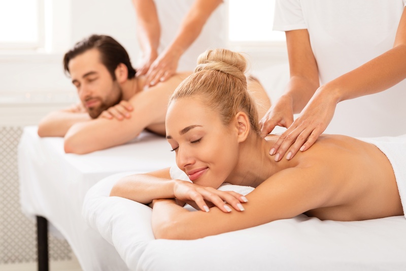 un hombre y una mujer reciben masajes en un spa
