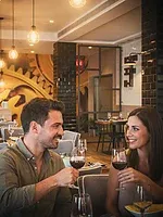 Couple enjoying wine at a romantic HTOP: Cocoon Spa dinner.