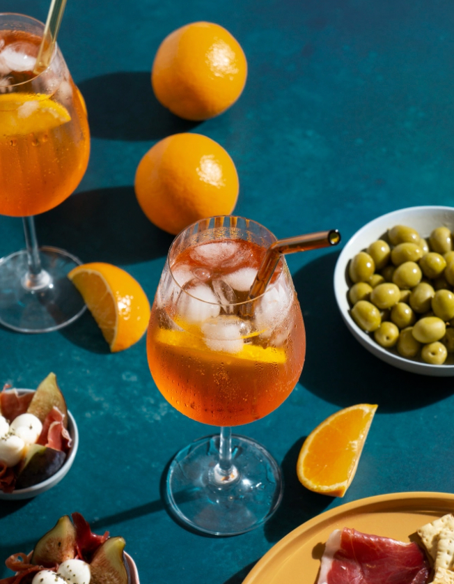a woman is dipping a piece of oysters into a cocktail .