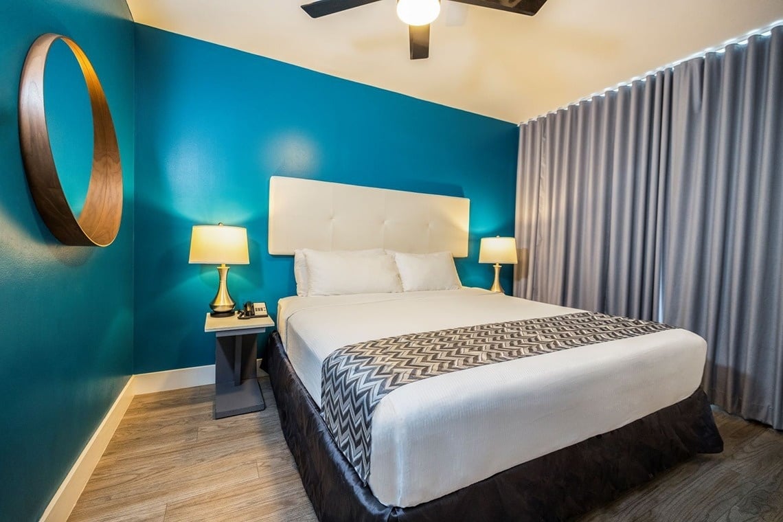 a hotel room with a large flat screen tv above the bed