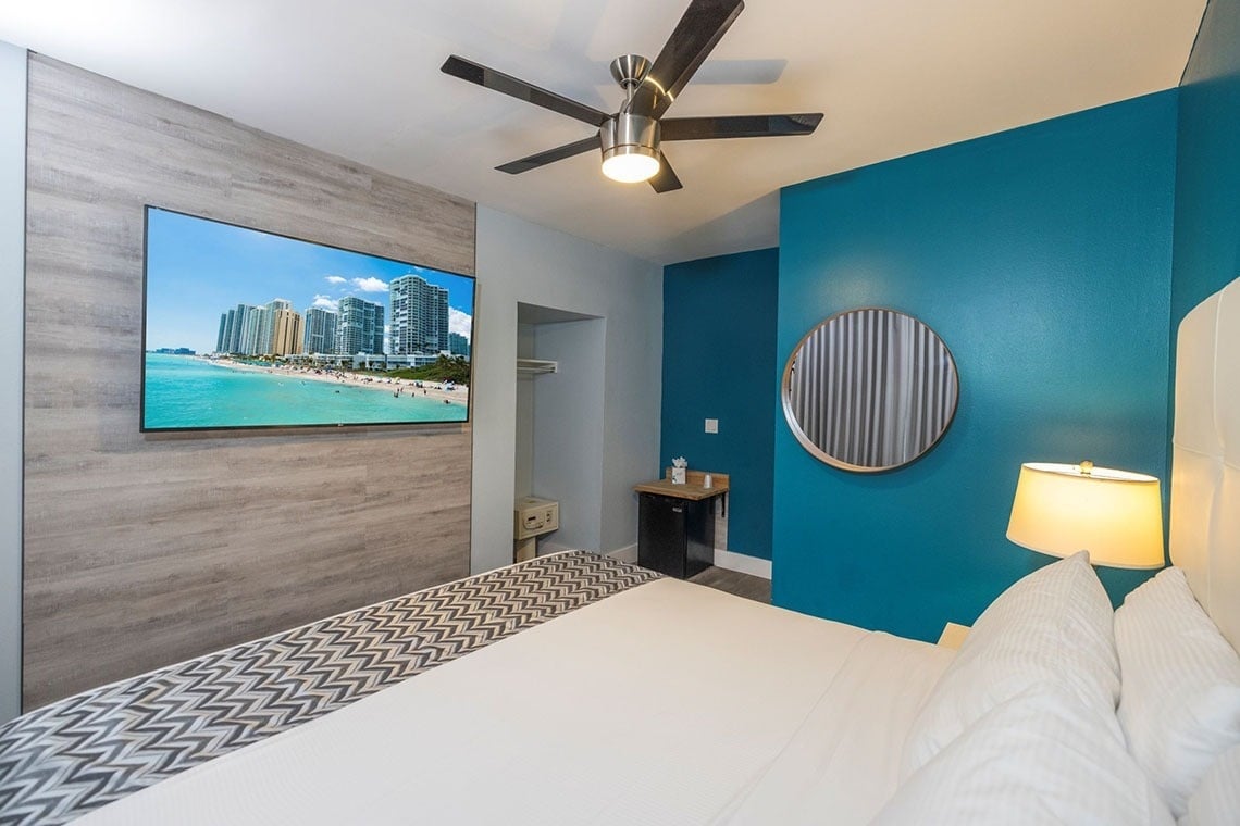 una habitación de hotel con una cama y una televisión en la pared