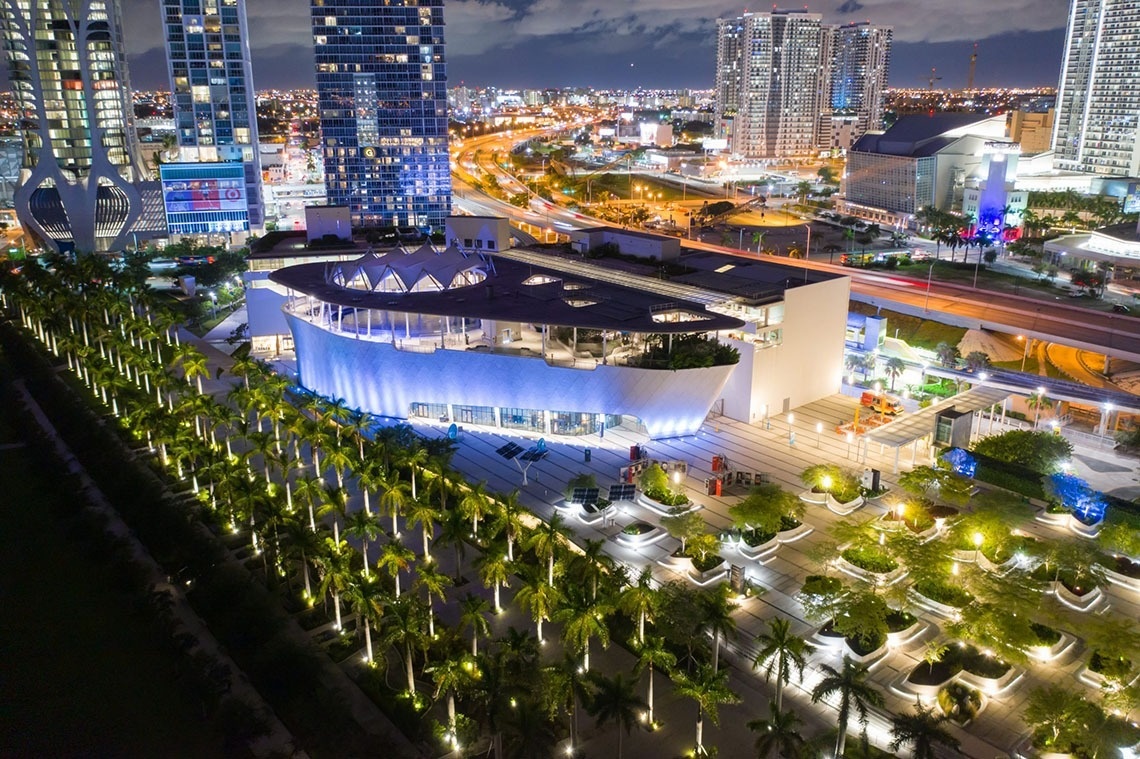 an aerial view of a large building with palm trees in front of it