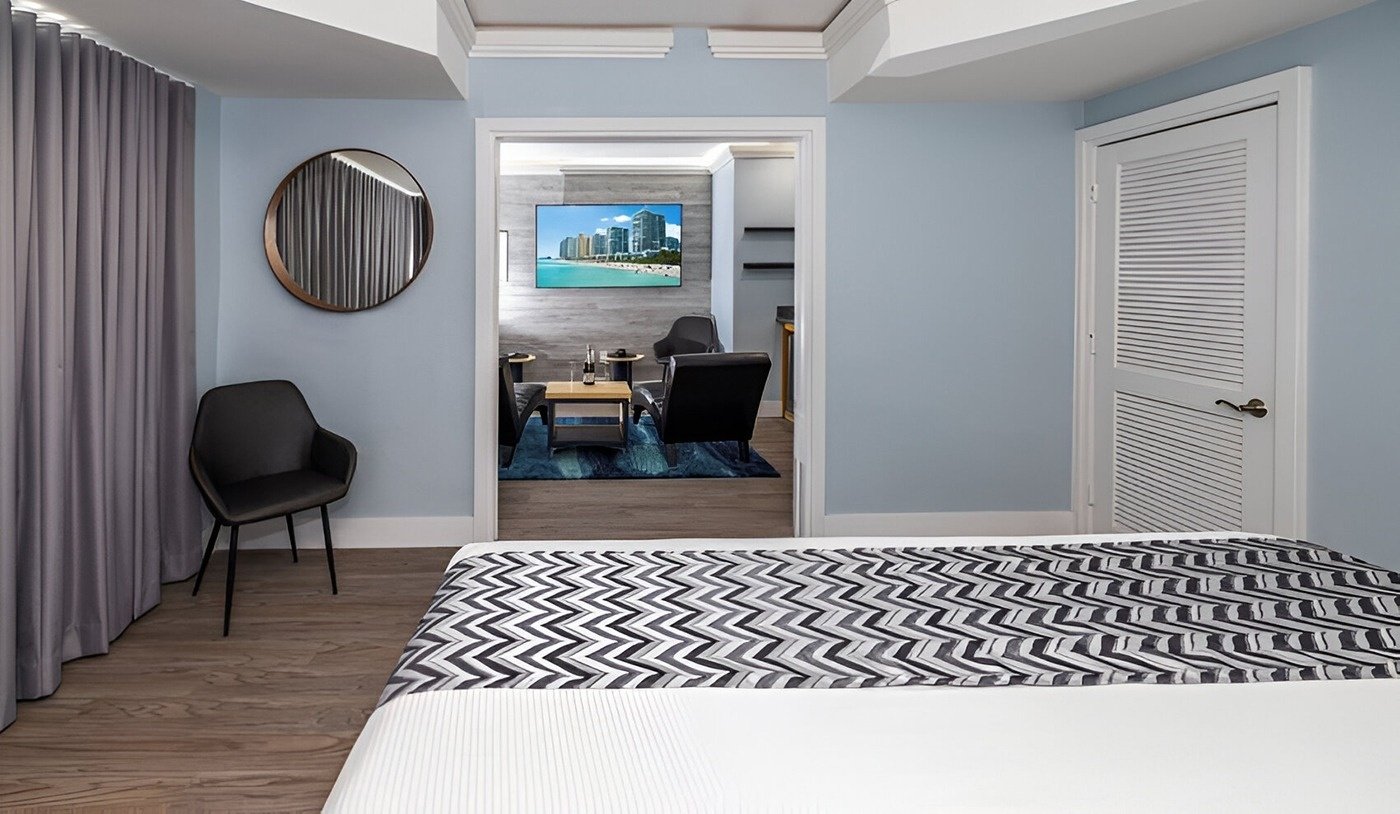 una habitación con una cama y una televisión en la pared