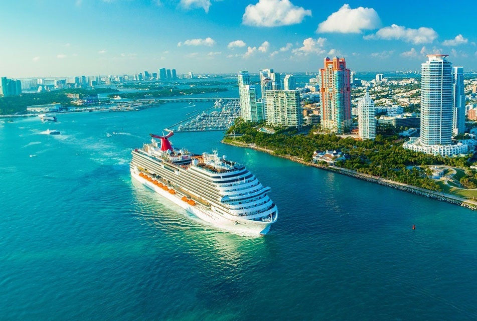 a cruise ship in the ocean with a city in the background