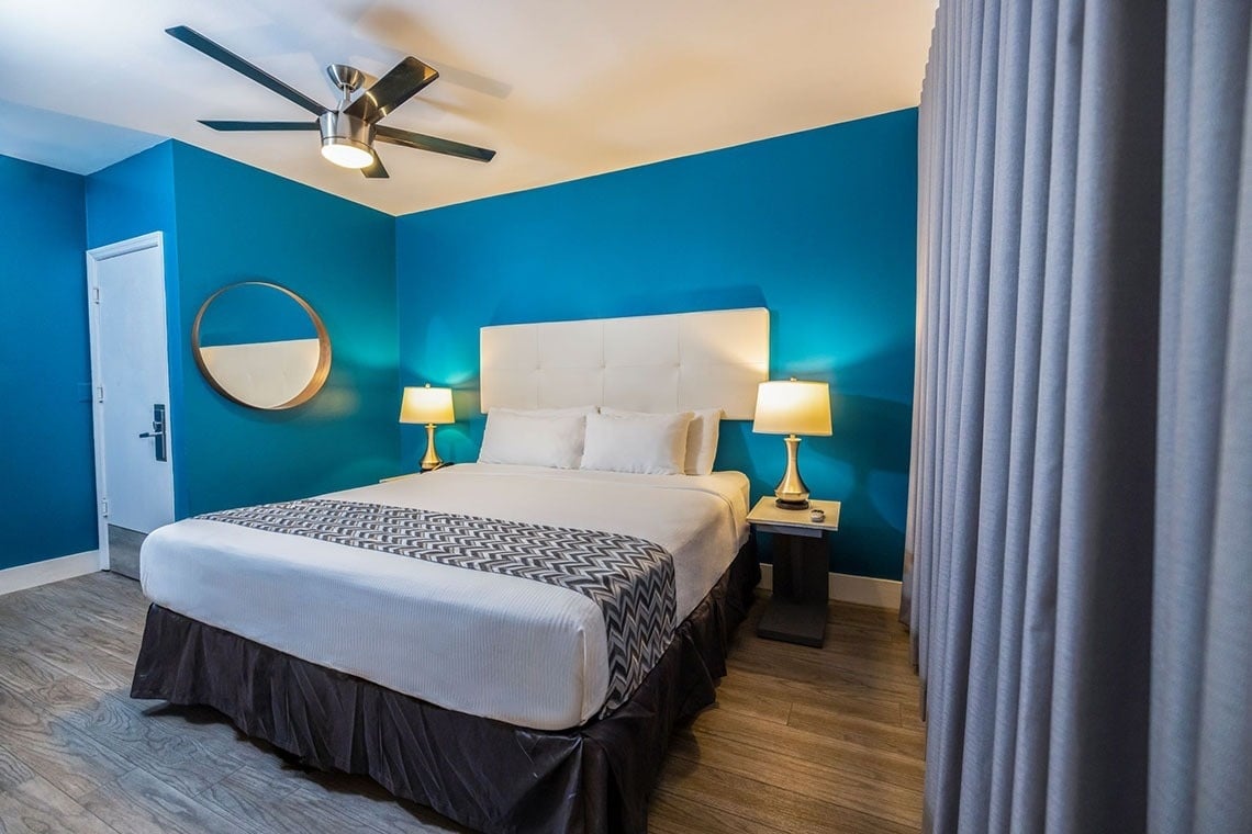 una habitación de hotel con una cama y un ventilador de techo