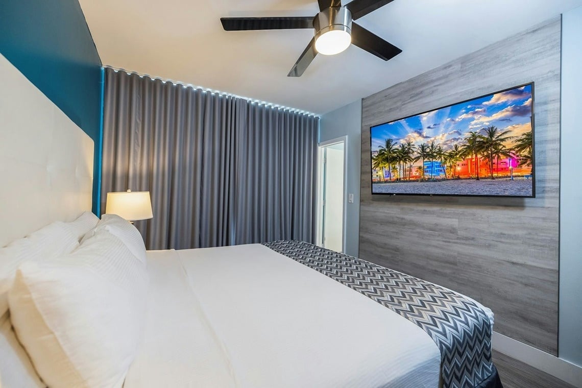 una habitación con una cama y una televisión en la pared