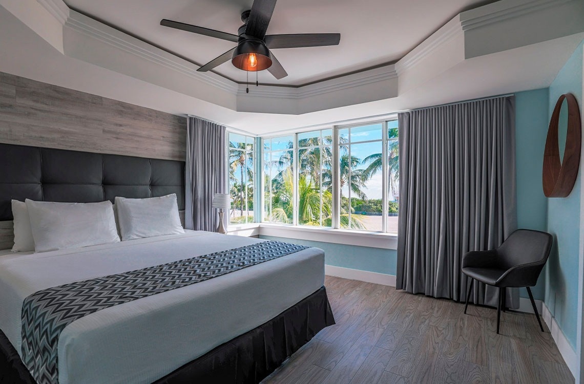 una habitación de hotel con una cama king size y un ventilador de techo