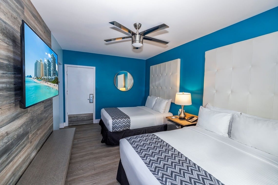 una habitación de hotel con dos camas y una televisión