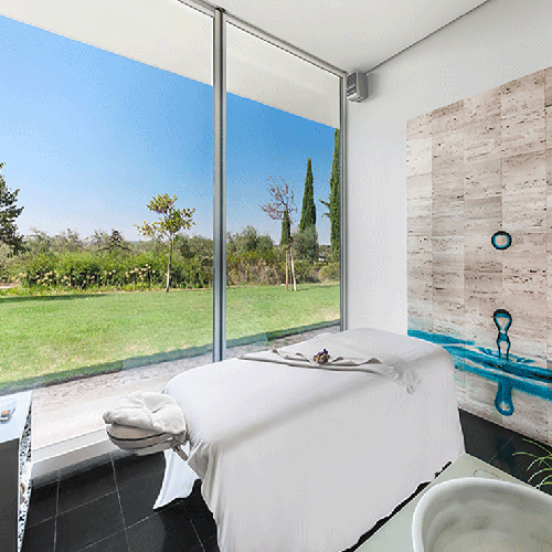 una habitación con una cama y una bañera y una pintura en la pared