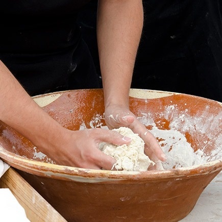 a person is kneading dough in a bowl