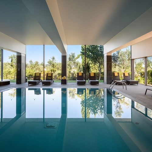 una piscina interior con sillas y un jacuzzi