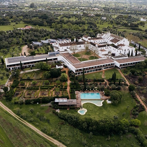 una vista aérea de un gran edificio blanco en medio de un campo verde