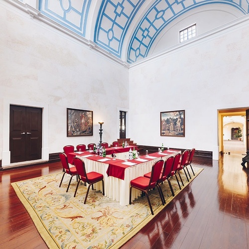 una sala de conferencias con mesas y sillas rojas