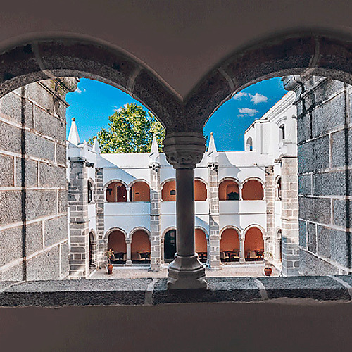 Patios del Convento do Espinheiro, con arquitectura clásica y vistas al cielo azul.