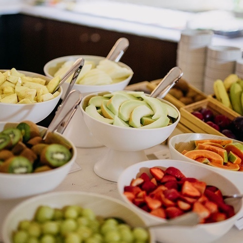 varios cuencos de frutas y verduras están sobre una mesa