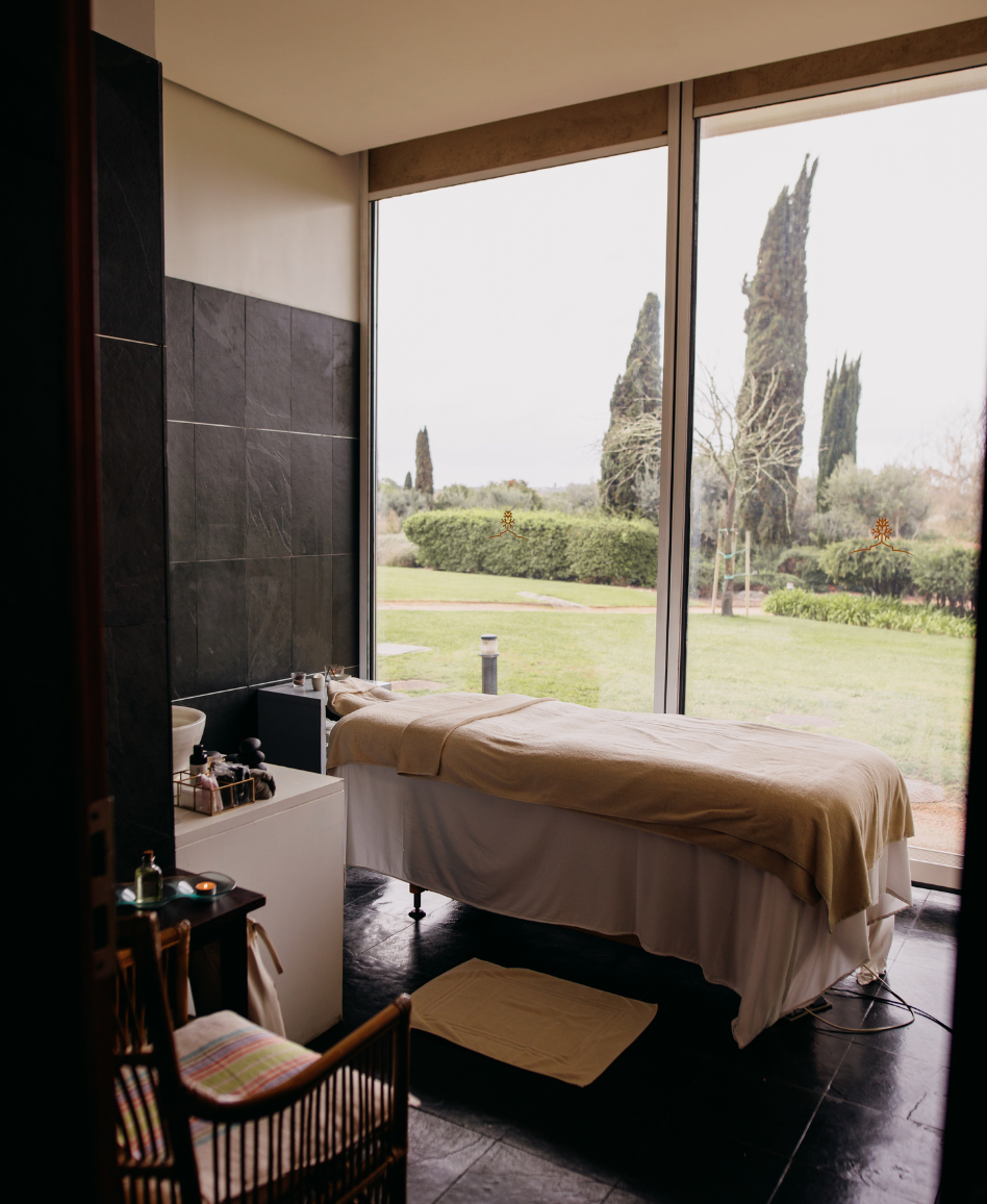 uma sala com uma cama de massagem e uma grande janela