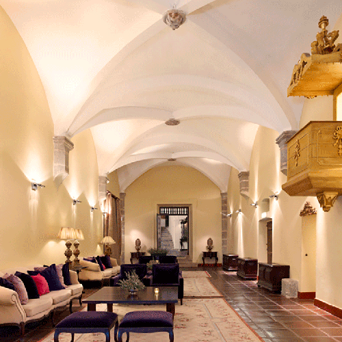 una sala de estar con sofás y sillas y un altar en la pared