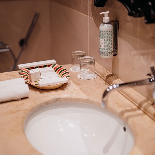 un baño con un lavabo y un dispensador de jabón