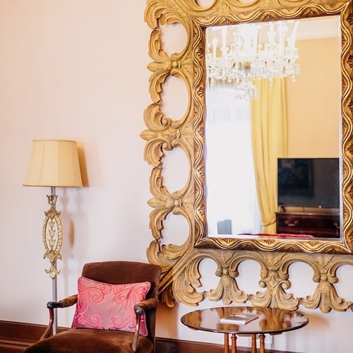 una silla y una mesa frente a un gran espejo