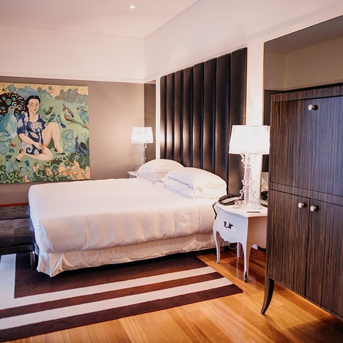 una habitación con una cama y una pintura en la pared