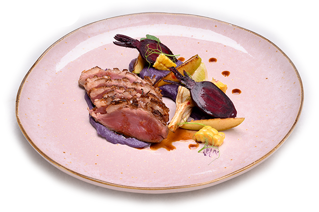 a pink plate with meat and vegetables on it