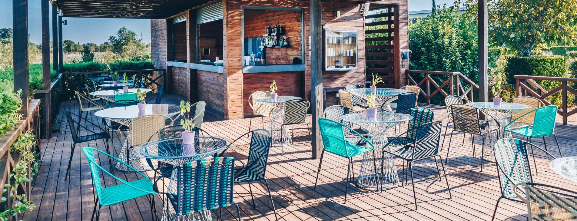 uma varanda de madeira com mesas e cadeiras e um bar