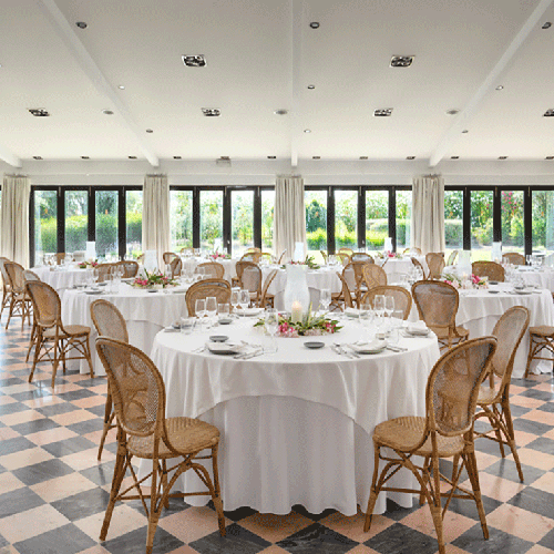 una habitación llena de mesas y sillas con un suelo a cuadros