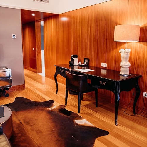 una habitación con un escritorio y una lámpara y un televisor