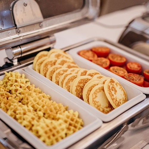 un buffet con panqueques y waffles y tomates
