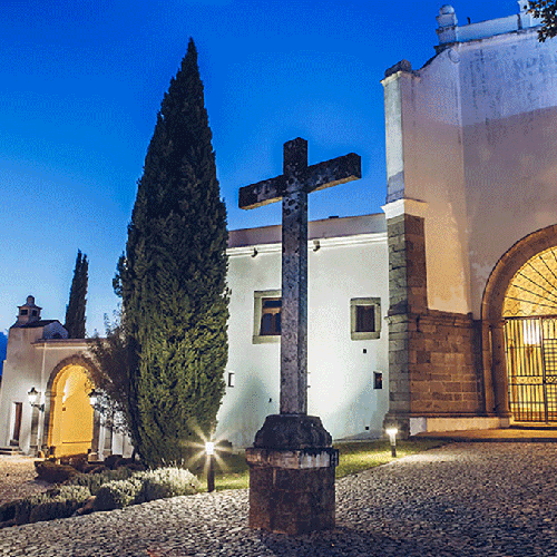 un edificio blanco con una cruz frente a él