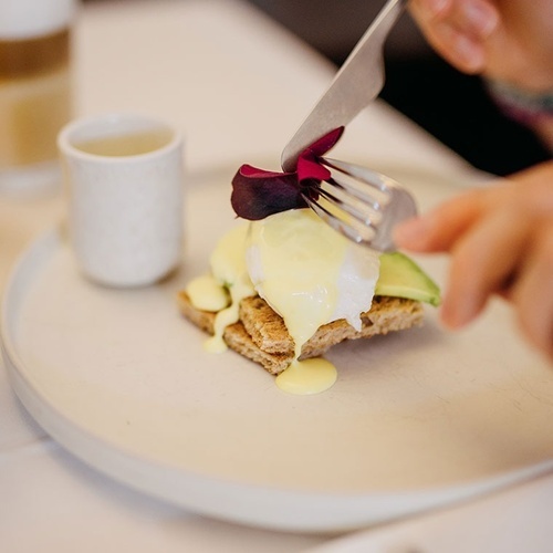 una persona está cortando un plato de comida con un cuchillo y tenedor