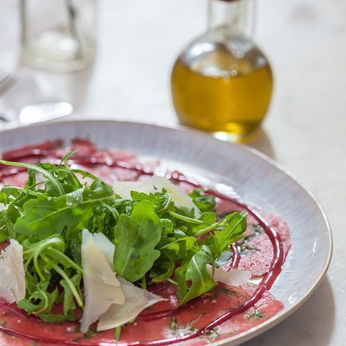 un plato de comida con una botella de aceite de oliva en el fondo