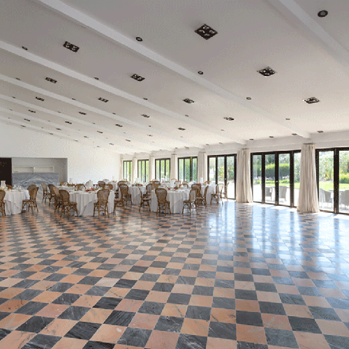 una habitación llena de mesas y sillas con un suelo a cuadros