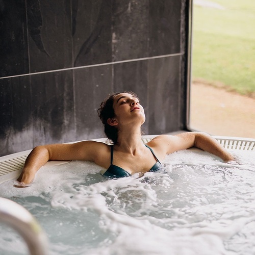 una mujer se relaja en un jacuzzi con los ojos cerrados