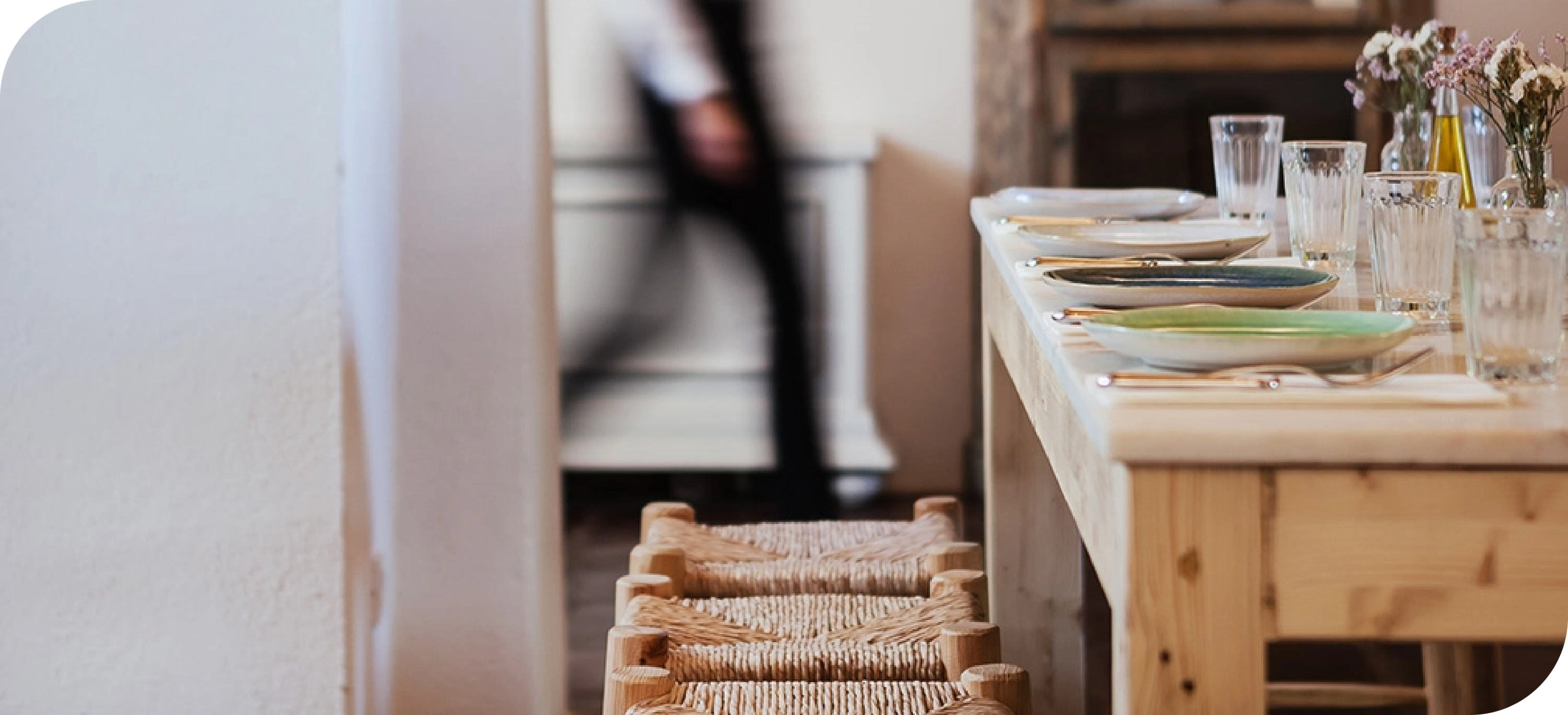 a long wooden table with plates and glasses on it