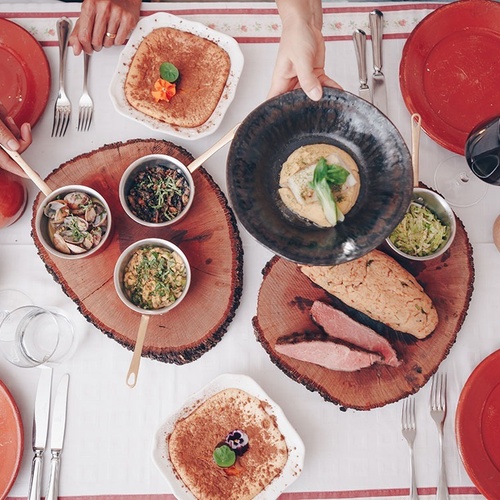 una mesa llena de platos de comida y copas de vino