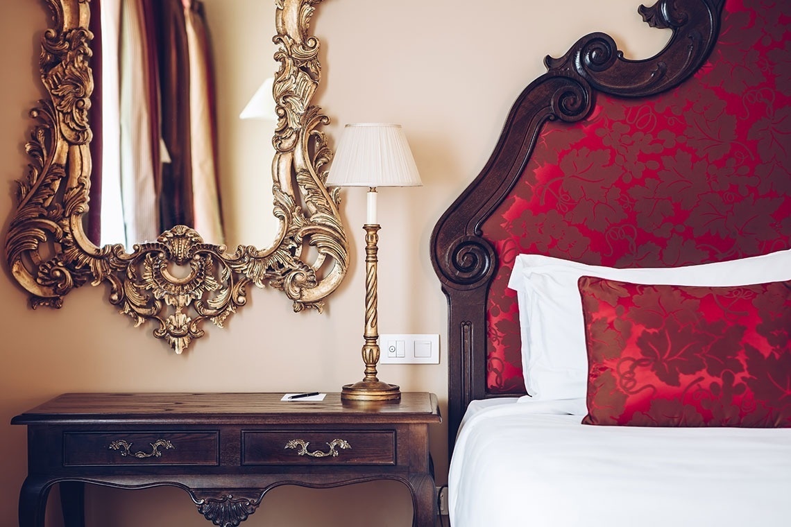 a bedroom with a bed and a lamp and a mirror