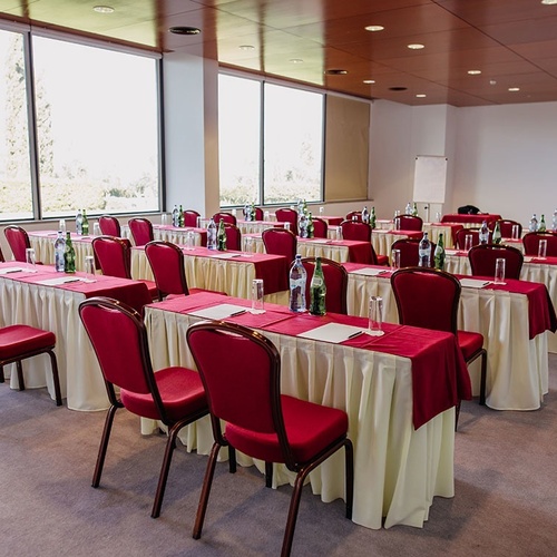 una sala de conferencias con mesas y sillas rojas