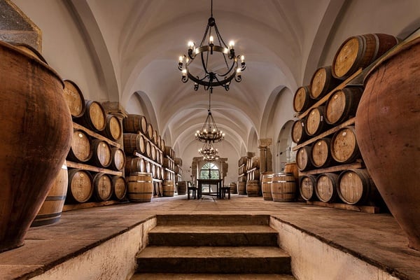 Convento do Espinheiro wine cellar with barrels and antique amphorae.