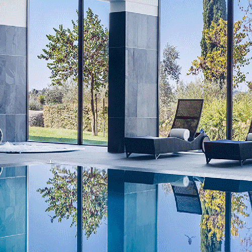 una piscina interior con jacuzzi y sillas alrededor