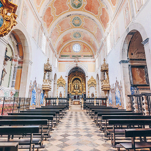 un interior de una iglesia con bancos y un altar