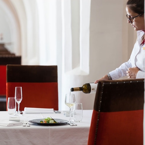 una mujer sostiene una botella de vino en un restaurante