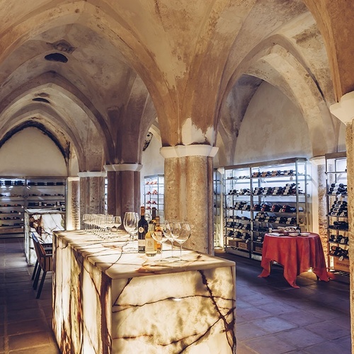una mesa con copas y botellas de vino en una bodega