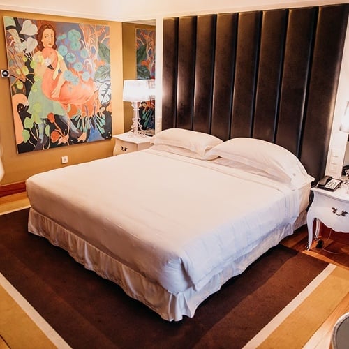 una habitación de hotel con una cama y una pintura en la pared