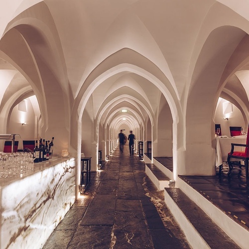 dos personas caminan por un largo pasillo de un restaurante